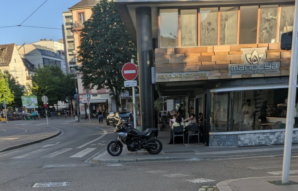 Une moto sur le trottoir devant un passage piéton