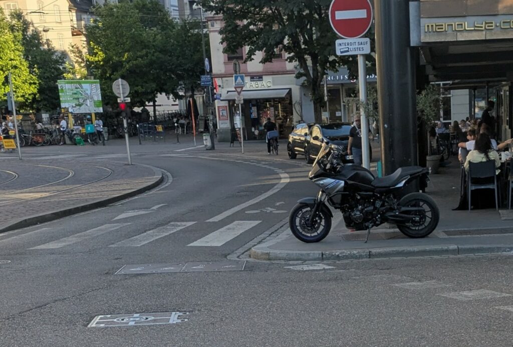Moto sur le trottoir devant un passage piéton